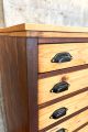 Zweifarbiger Schubladenschrank mit schwarzen Muschelgriffen